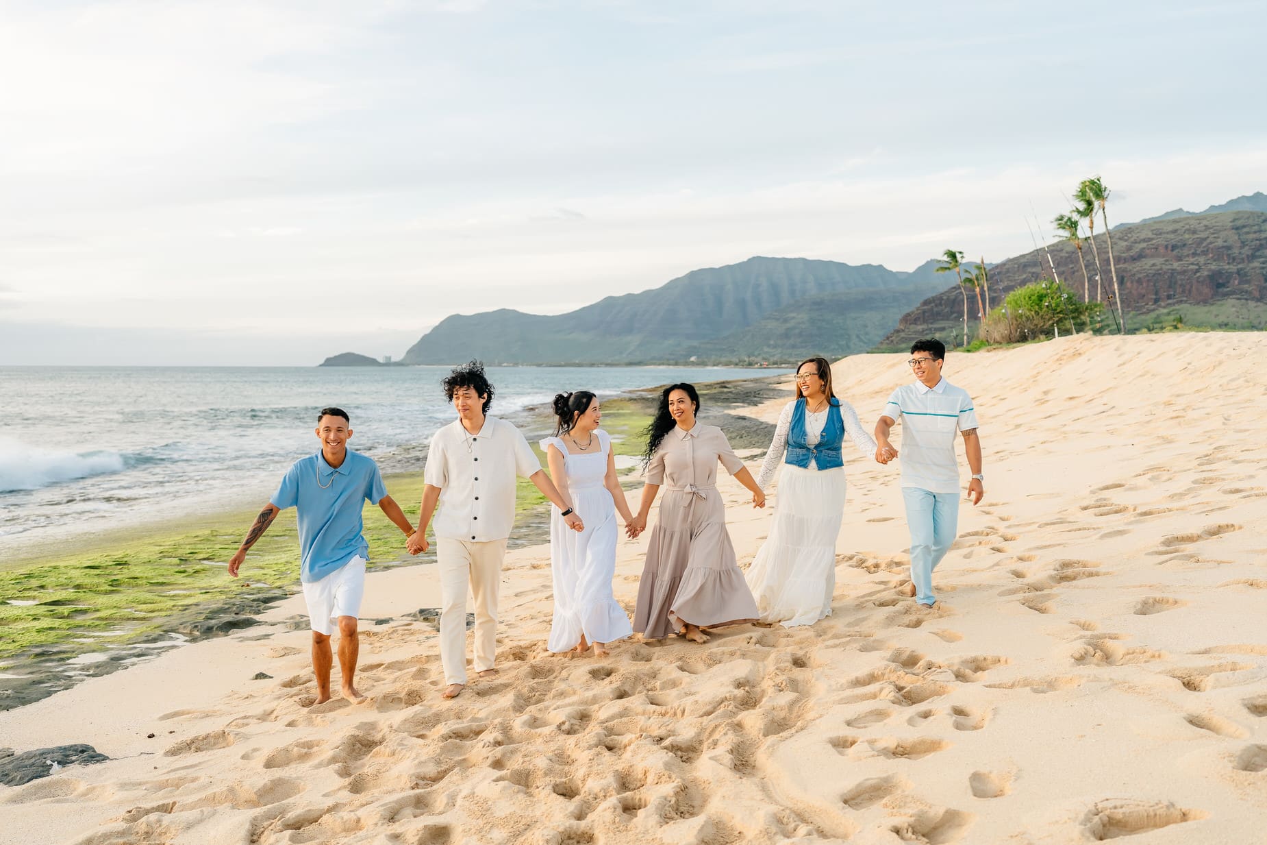 A group of people walking on a beach.